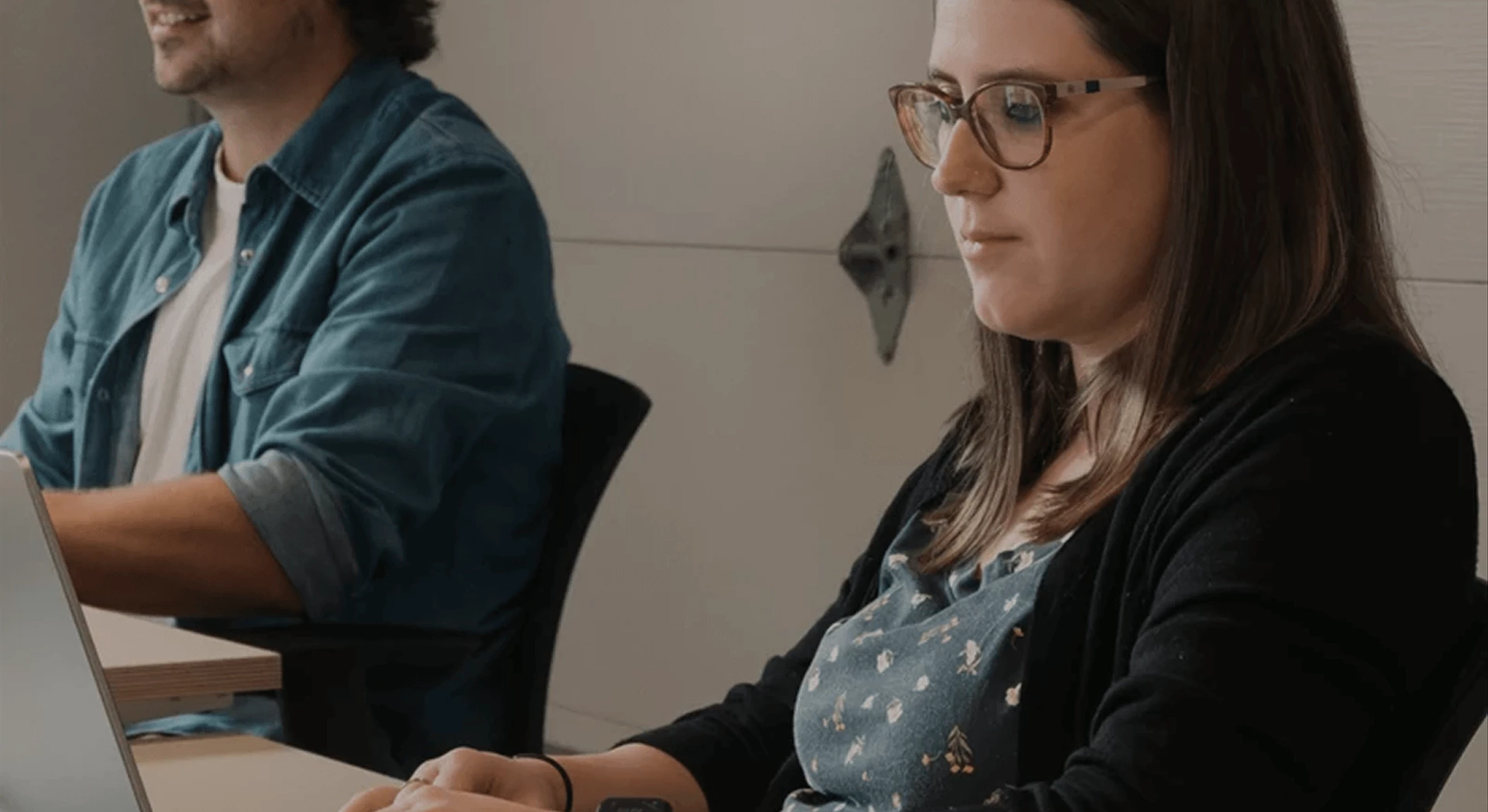 Photo de deux membres de l'équipe travaillant sur leur ordinateur