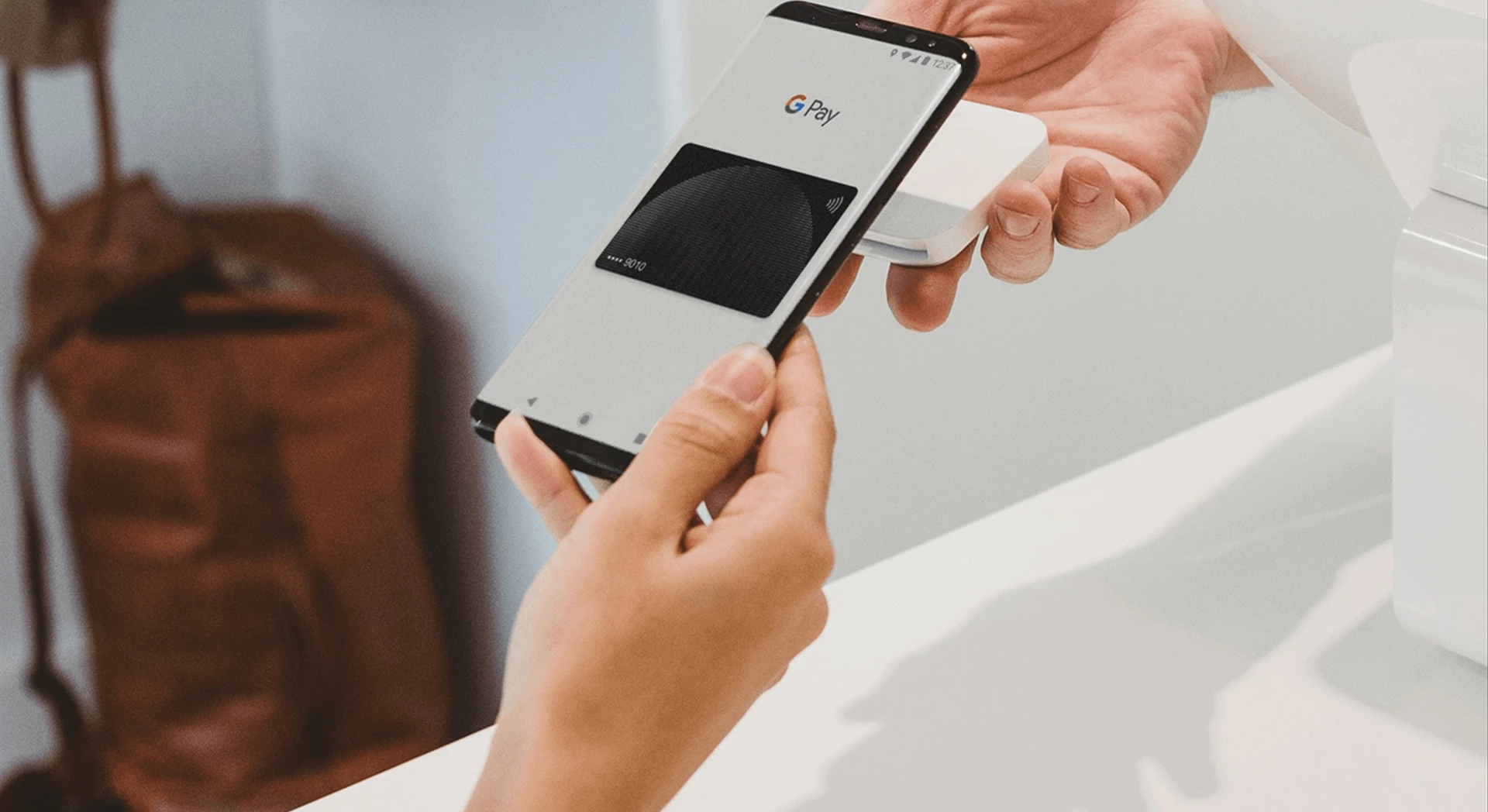 Photo of a person paying at a checkout with their mobile phone