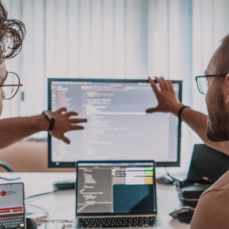 Photo of two people discussing in front of a computer