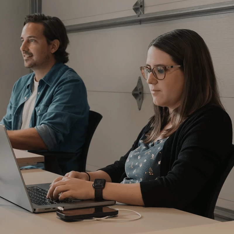 Photo de deux membres de l'équipe travaillant sur leur ordinateur